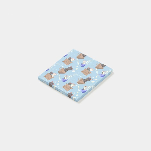 Katter i låda och mjölk droppar i blått post-it block (Vinklad)