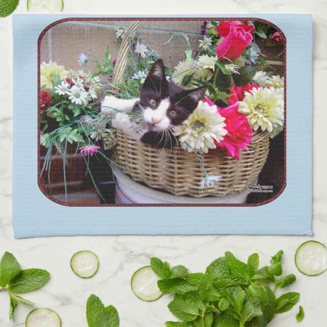 Kattunge i en korg kökshandduk (Vikta)