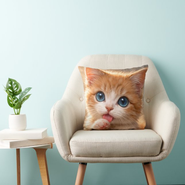 Kattunge med blå ögon slickar på tass kudde (Stol)