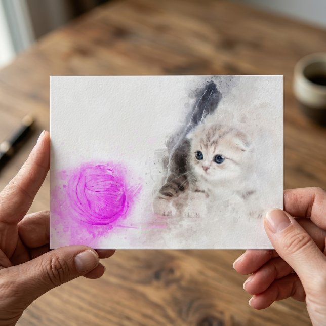 Kattunge som leker med en rosa garnboll i akvarell vykort (Kitten playing with a pink yarn ball watercolor. postcard)