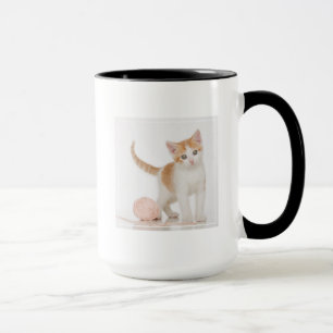 Kattungen bredvid boll av stränger mugg