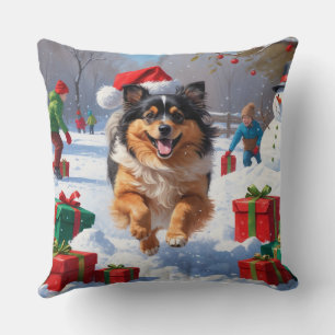 Keeshond-hund springer i snö med julhatt kudde