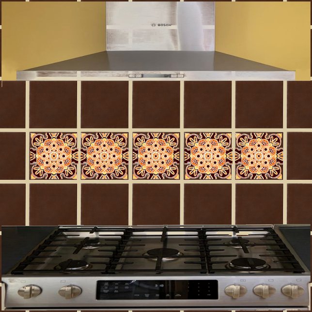 Keramiskt plattor med geobrun, guld och orange kakelplatta (Orange and brown geometric tile shown on a kitchen backsplash with brown field tiles.)