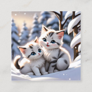 Kittens som leker i vita snö är en charmerande fyrkantigt visitkort