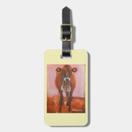 Ko på rosa bagagehandväskamärkre eller keychain bagagebricka