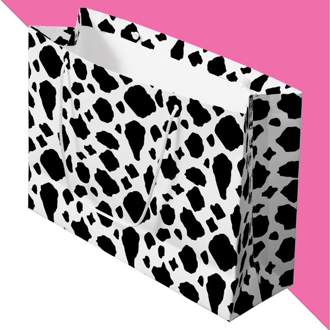 Ko-print svart och vit (A gift bag with a black and white cow pattern.)
