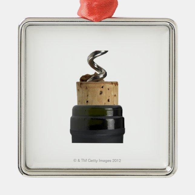 Korkskruv och kork som fotograferas på vit julgransprydnad metall (Framsidan)