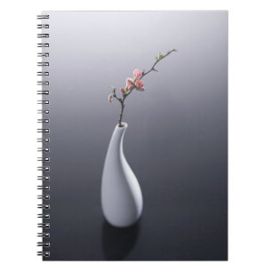Körsbärsröd blommar i vas anteckningsbok med spiral