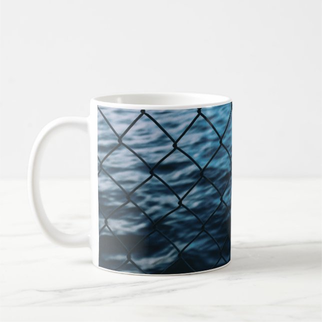 Kroppen i vatten framför kedjestängslet kaffemugg (Vänster)