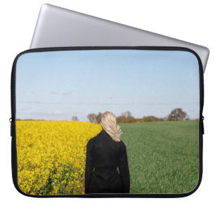 Kvinna i svart jackande på grönt gräs fält laptop fodral
