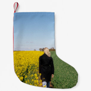 Kvinna i svart jackande på grönt gräs fält liten julstrumpa