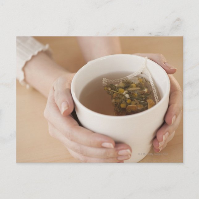 Kvinna som håller kopp med chamomile-te vykort (Framsida)