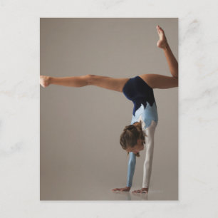 Kvinnlig gymnast (12-13) som utför handstående vykort