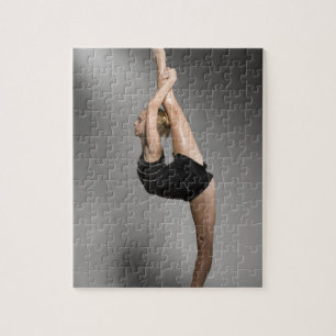 Kvinnlig gymnast som sträcker, skjuten studio pussel