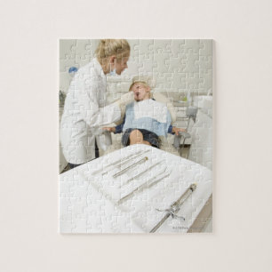 Kvinnlig tandläkare som undersöker liten pojke pussel