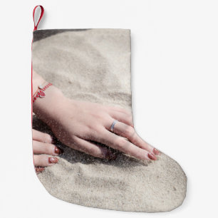 Kvinnor ljugande på vit sand liten julstrumpa