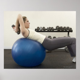 Kvinnor som använder motionsvikter i boll och hand poster