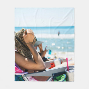 Kvinnor som ljuger på sol lounger som täcker henne fleecefilt