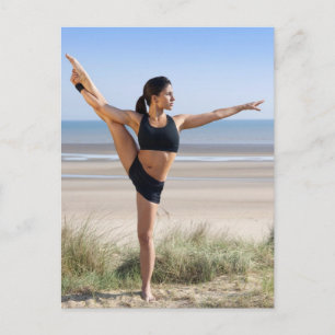 Kvinnor som tränar yoga på strand med vykort