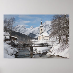 Kyrka i snö med Alperna i vinter Poster