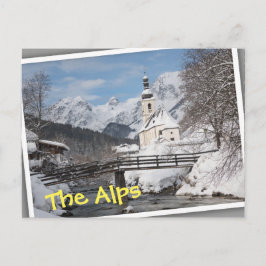 Kyrkan i snö med Alperna berg på vintern Vykort
