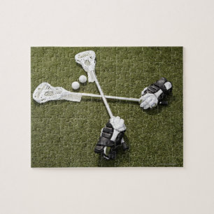 Lacrosse sticks, handskar och bollar på konstgjord pussel