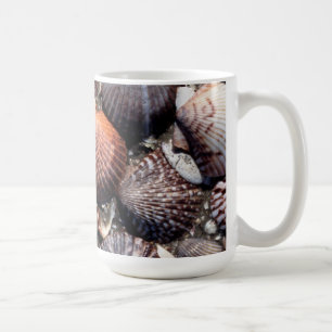 Langetterade färgrika snäckskal på en svart San Kaffemugg