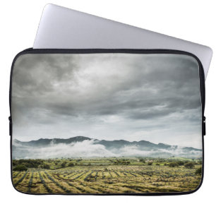 Lantliga skördfält under molnig himmel laptop sleeve