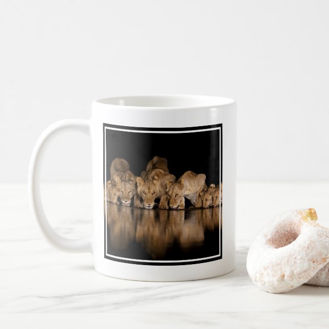 Lejonflock dricker vid vattenhålet på natten kaffemugg (Med munk)