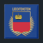 Liechtenstein Flagga Shield Magnet<br><div class="desc">Liechtensteins nationella flagga infiltreras i ett faux guld-skölsystem som sätts på Faux guld löv.</div>