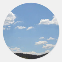 Liggande med grönt backe, träd och moln