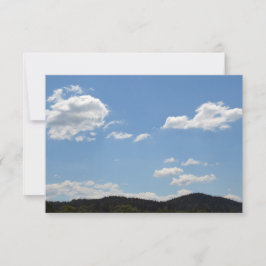 Liggande med grönt backe, träd och moln tack kort