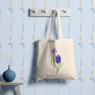 Lila och ljuslila vildblommor med din initial. tygkasse