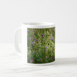 Lila vild blommor i en grönt kaffemugg