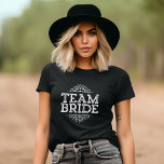 Lila & White Cute Team Bride Bröllopsfest Gift T-shirt<br><div class="desc">Utformning av Trendiget Chic Girly Modern Elegant Typography läser "Team Bride" med Finare Rulla Ram Gräns. Perfektens gåva till brud, brudgumm och bröllopsfest till bära medan du får redo på din bröllopsdag! Klicka på knappen "Anpassa den" om du vill anpassa framsidan med namn eller annan anpassningsbar för en verkligt unik...</div>