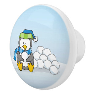 Lilla penguin sitta med snöbullar knopp