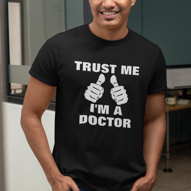 Lita på mig att jag är Doktor T Shirt (Man wearing a black "Trust Me, I'm A Doctor" t-shirt with thumbs-up graphic.)
