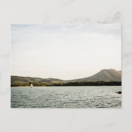 Liten båt seglar på en sjö på eftermiddagen vykort