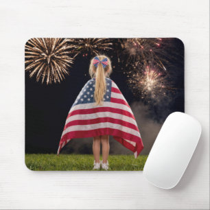 Liten flicka insvept i en amerikansk flagga musmatta