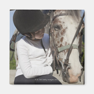 Liten flicka med henne häst magnet