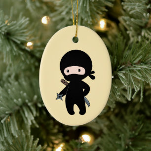 Liten ninja som håller kaststjärna på gul bakgrund julgransprydnad keramik