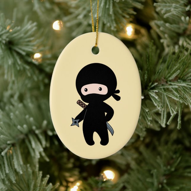 Liten ninja som håller kaststjärna på gul bakgrund julgransprydnad keramik (Träd)