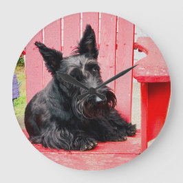 Liten Scottie i en stor röd stol Klocka