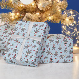 Liten strumpmonkey med jultomtehatt blå jul presentpapper