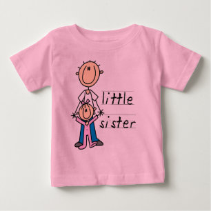 Liten syster med T-shirts och gåvor av storebror