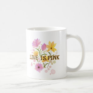 "LIVE IS PINK" är skrivet i en mörk Kaffemugg