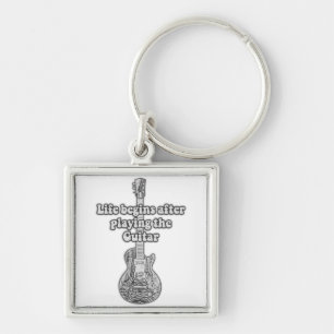 Livet börjar efter att ha spelat gitarren. fyrkantig silverfärgad nyckelring