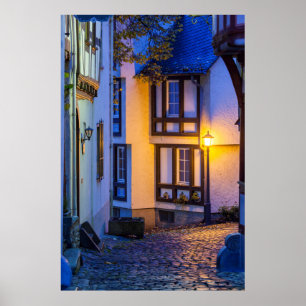 Ljus gatlykta på kullerstensgata poster