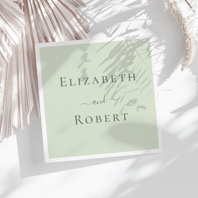 Ljust Salviagröna Minimalistiska Par Namn Bröllop Pappersservett (Pale Sage Green Minimalist Couple Names Wedding Napkins on a sunny table with white dry flowers.)