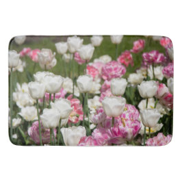 Ljusvita och rosa tulpaner på ett soligt badrumsmatta